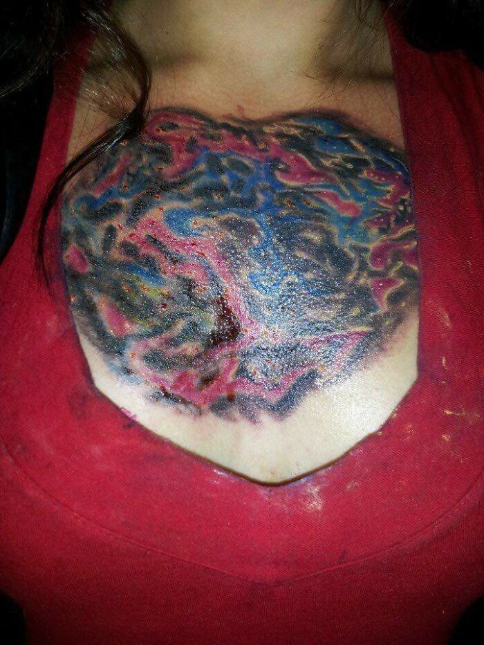 Poorly done colorful tattoo on a person's chest, featuring abstract patterns.