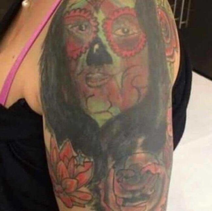 An example of a poorly done tattoo featuring a colorful abstract face on an arm.