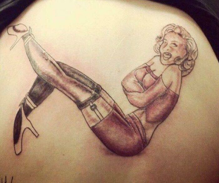 Badly-done tattoo of a woman in stockings and heels, showcasing poor artistic e*******n and style.