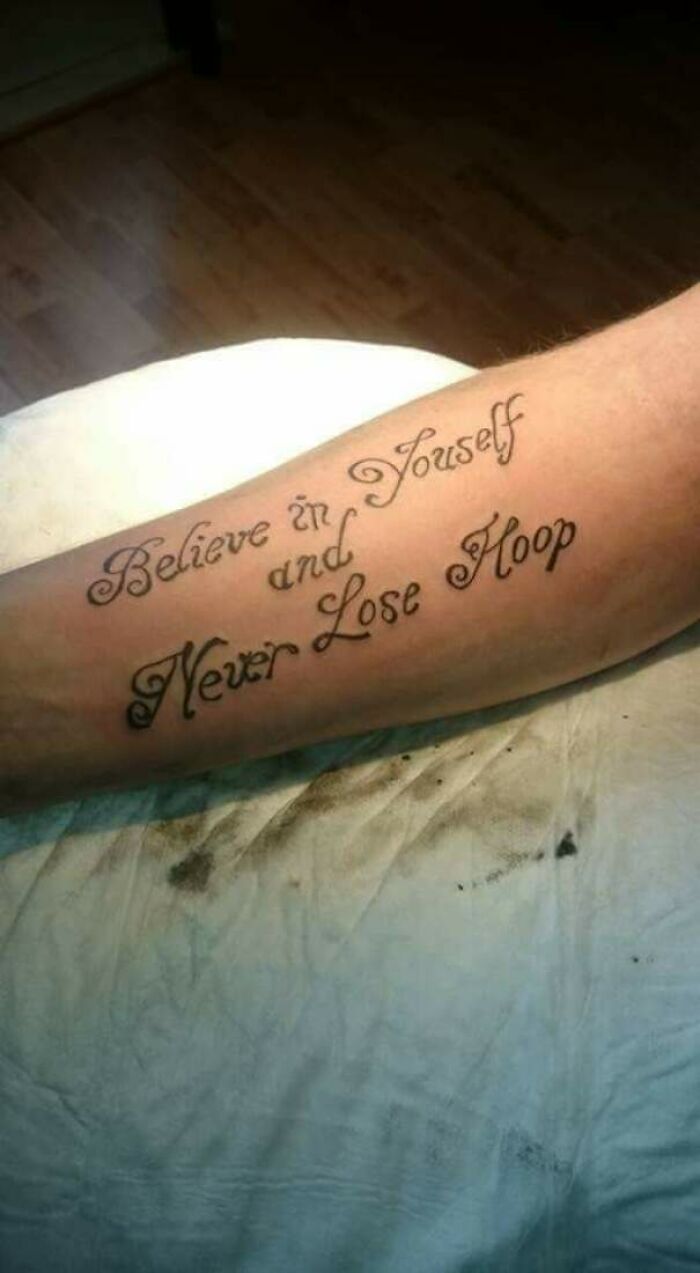 Poorly done tattoo on arm with misspelled quote, showcasing unfortunate tattoo mistakes.