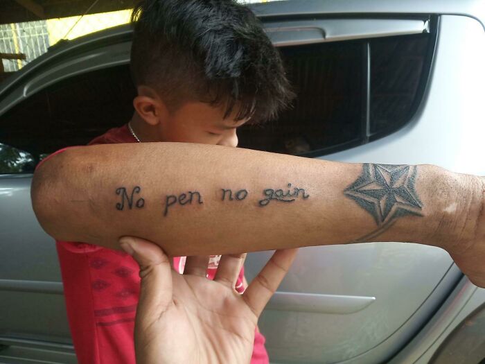 Poorly done tattoo on a forearm reading "No pen no gain" with a star design.