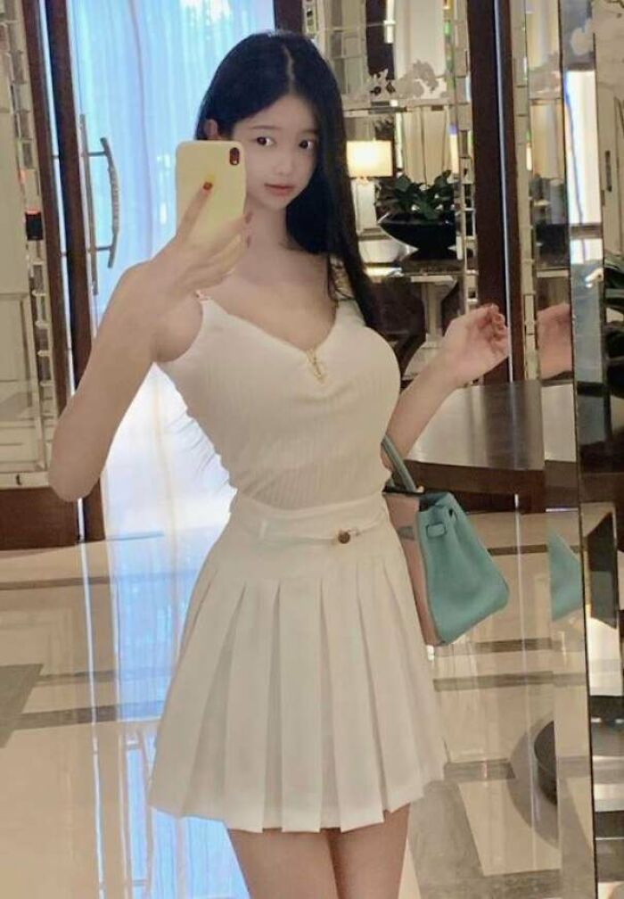 Young woman taking a selfie in mirror with obvious photo manipulation exposing Instagram reality fakest photos online.