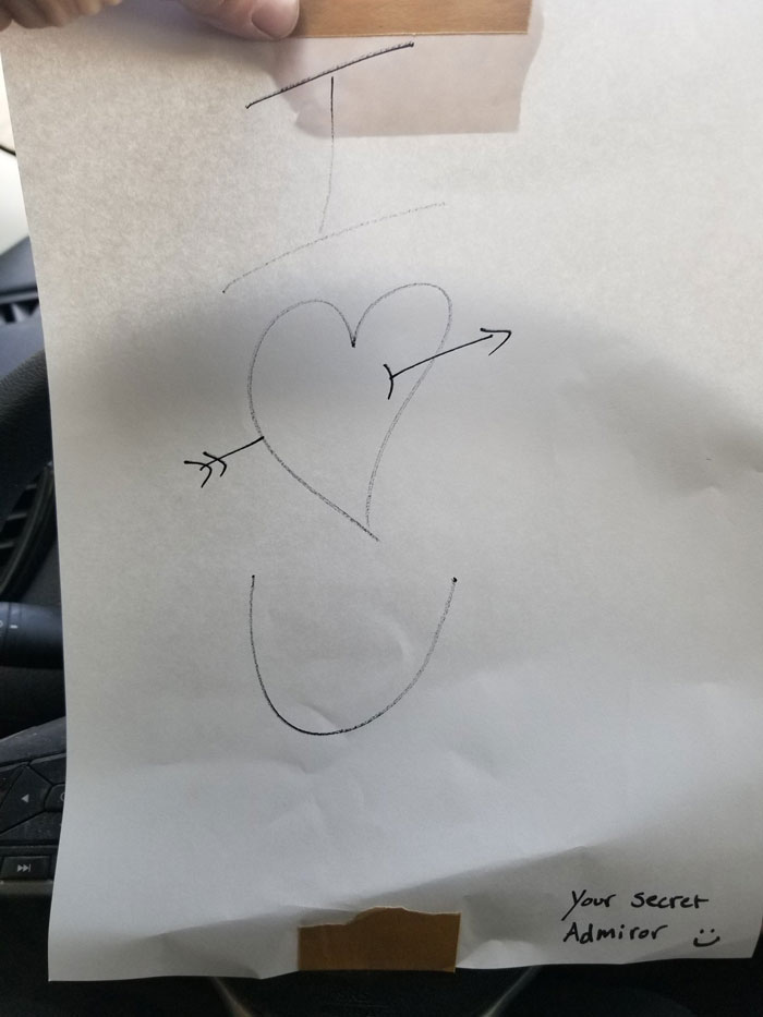 Handwritten windshield note with a heart and arrow drawing, signed by a secret admirer, found on a car windshield.