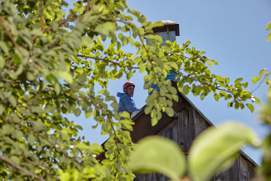 The Painter-Climber Paints The Chimney. A Worker On A Blue Sky Background.