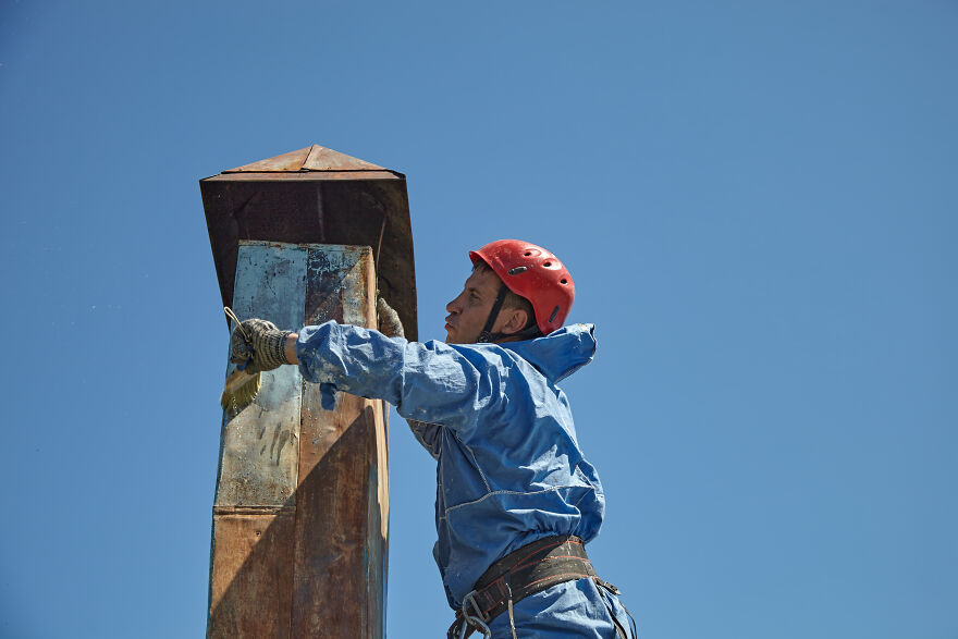 The Painter-Climber Paints The Chimney. A Worker On A Blue Sky Background.