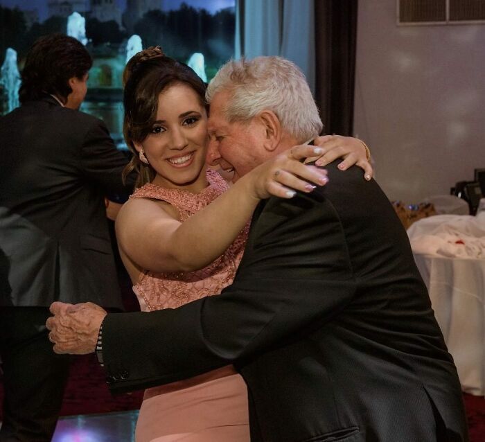 Grandfather joyfully hugging granddaughter at event, capturing grandparents' emotional reaction.