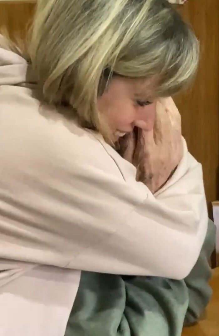 Elderly woman embracing granddaughter, touched by her tattoo, eliciting an emotional reaction.