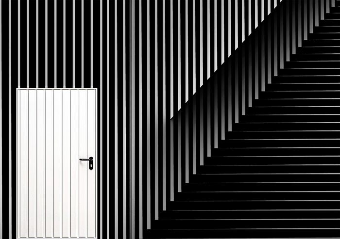 Minimalist black and white photography featuring geometric patterns and a door, showcasing powerful photography elements.