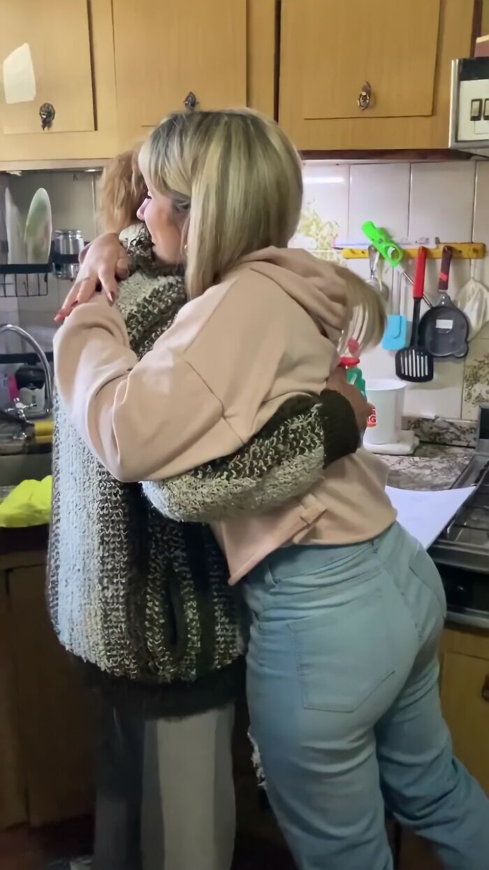 Grandparents' emotional reaction as they embrace their granddaughter in the kitchen after seeing her new tattoo.