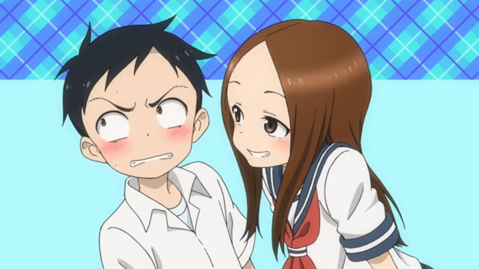 Cute anime couple in school uniforms, playfully interacting with blue checkered background.