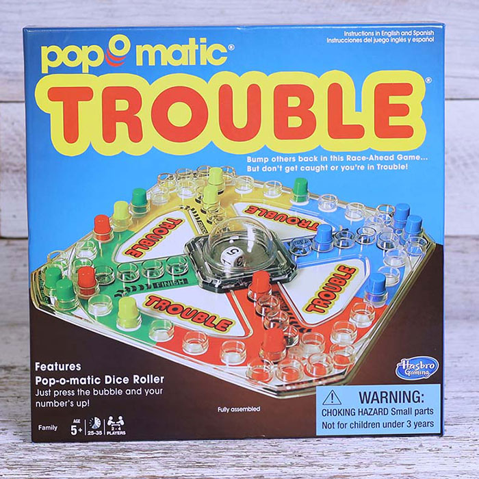 Board game Trouble with pop-o-matic dice roller on a wooden surface, ideal for a night in with friends and family.