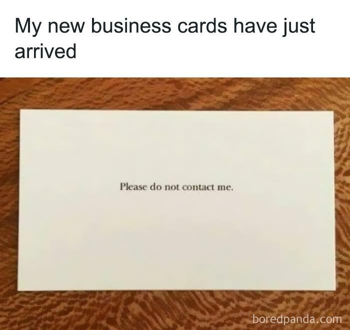 Introvert Nation meme showing a business card with text please do not contact me on a wooden surface.