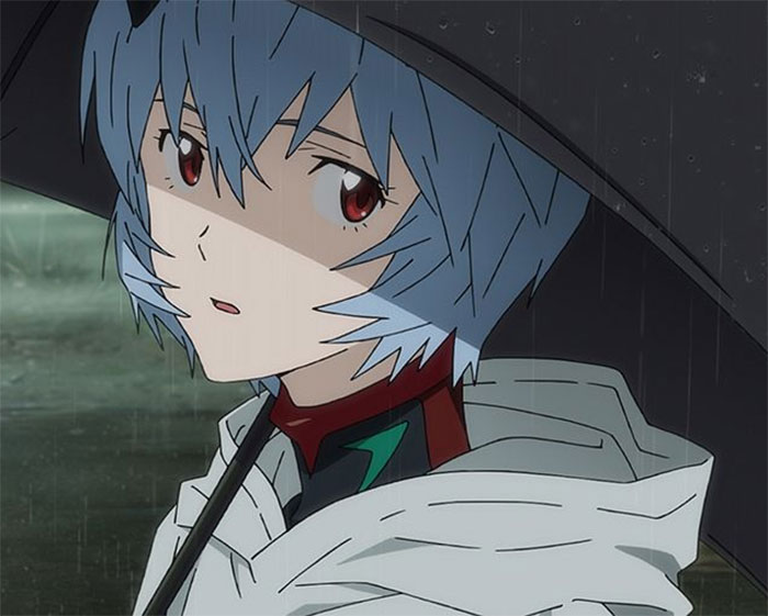 Anime character with blue hair and red eyes standing under an umbrella in the rain.