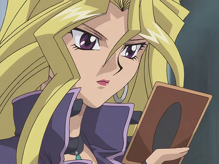 A female anime character with long blonde hair and purple eyes intently holding a card, known among fans as a favorite character.