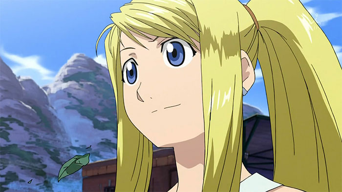 Blonde female anime character with blue eyes and a serene expression against a mountain backdrop, representing fan favorites.
