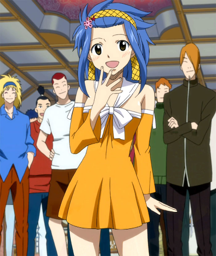 A female anime character with blue hair in an orange dress standing happily among friends.