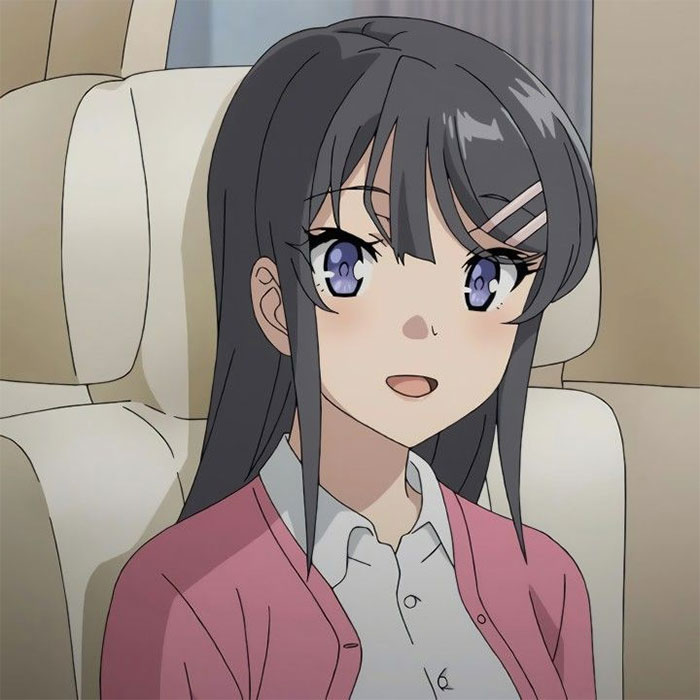 Female anime character with long dark hair, wearing a pink cardigan and sitting in a car seat, smiling.