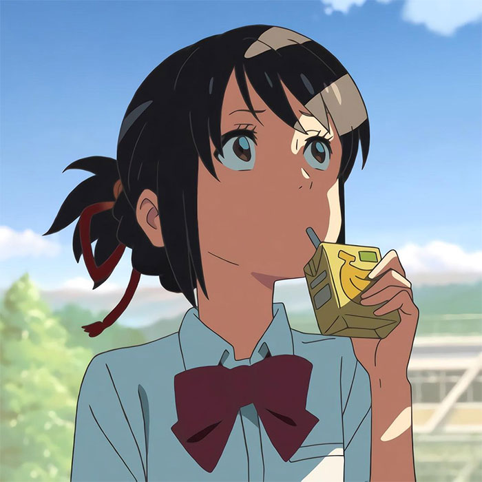 Anime character sipping from a juice box on a sunny day.