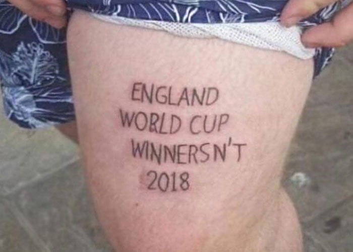Tattoo fail with misspelled "England World Cup Winnersn't 2018" on a person's thigh.