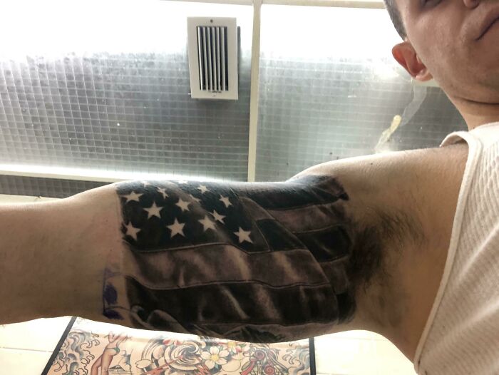 Tattoo of a black and white American flag on a person's inner arm, considered a potential red flag by some people.
