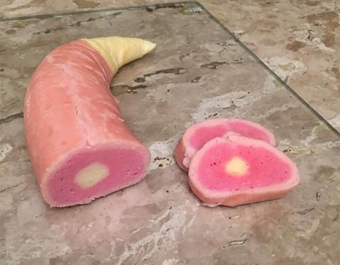 Unappetizing and strange food with a threatening aura, resembling a horn shape and unusual colors on a tiled floor.