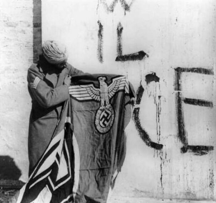 Sikh Soldier Of The Indian Red Eagle Division Showing A Captured German Flag After Taking Over Monte Cassino, Italy In May, 1944