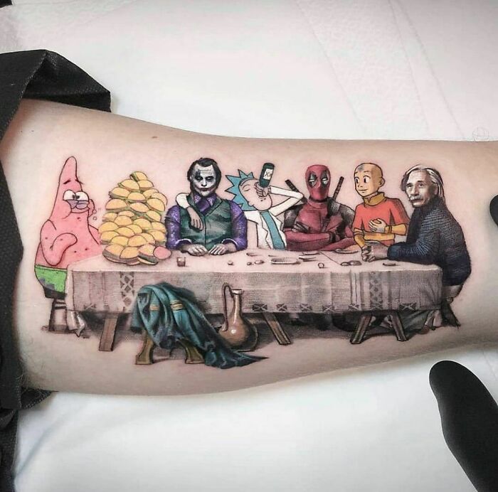 Crazy tattoo featuring cartoon and comic characters inspired by "The Last Supper" on an arm.