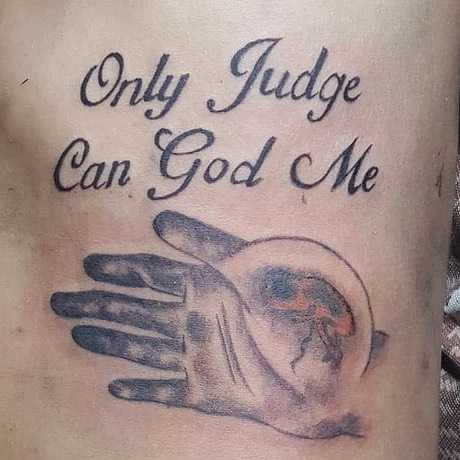 Tattoo fail of a hand with text "Only Judge Can God Me", showcasing a humorous design mistake.