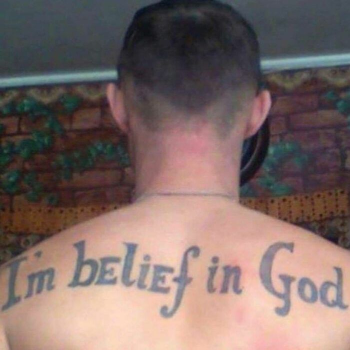 Back tattoo misspelling "I'm belief in God," showcasing a tattoo fail.