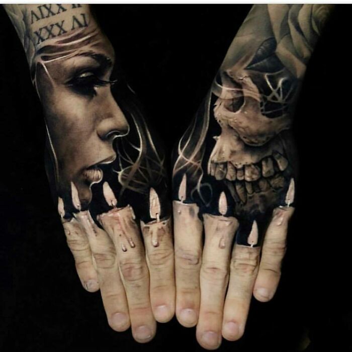 Two hands featuring intricate tattoos: a woman's face and skull art with candles on fingers.