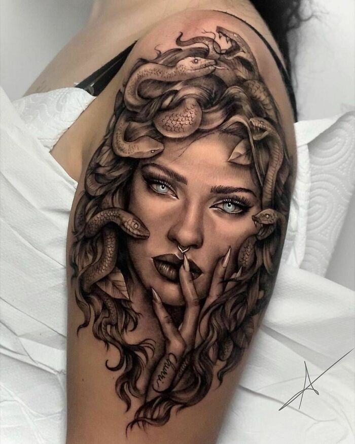 Tattoo of a woman's face with snakes on an arm, showcasing unique and crazy ink designs.