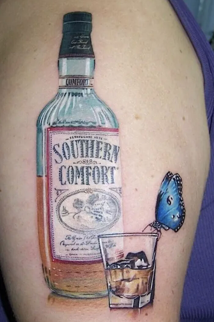 Tattoo of a Southern Comfort bottle with a butterfly perched on a whiskey glass, seen as a major red flag by some.