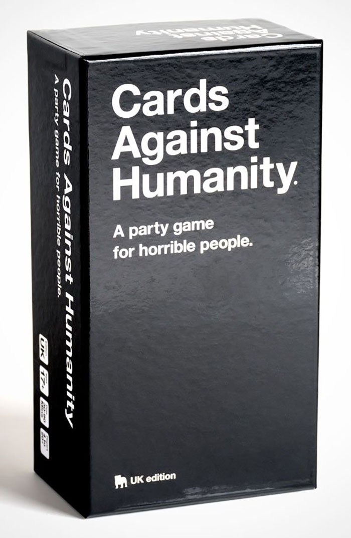 Cards Against Humanity game box standing on a white surface, popular board game for a night in.