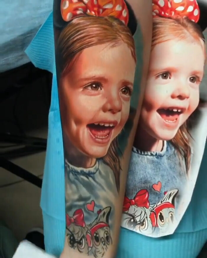 Realistic tattoo of a smiling child with vibrant colors, showcasing creative ink work on skin.
