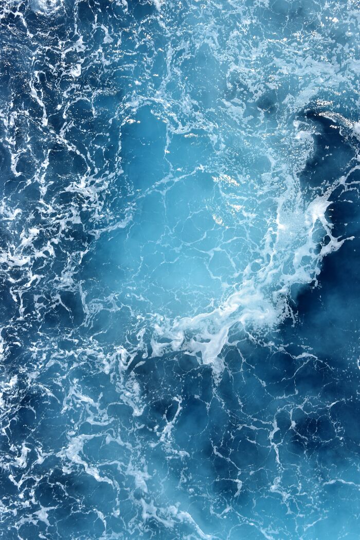 Turbulent ocean water with frothy white waves and deep blue hues showcasing creepy ocean facts visually. - 23