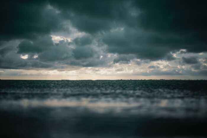 Dark stormy ocean horizon under heavy clouds, illustrating creepy facts about the ocean and its mysterious depths. - 27