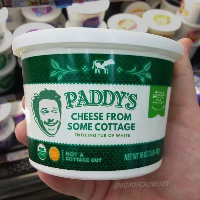Hand holding a container of Paddy's cheese labeled as cheese from some cottage, a funny example of food with threatening auras.