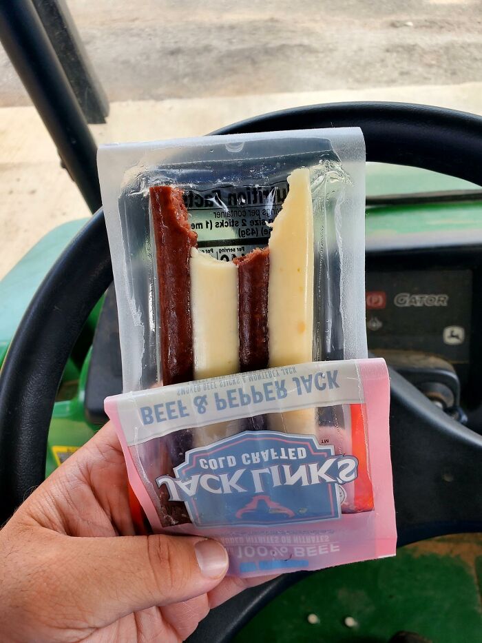 Hand holding a partially eaten beef and pepper jack snack, an example of food with threatening auras shared online.
