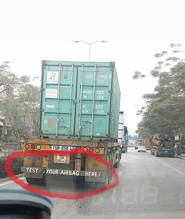 Rear view of a truck with a sign circled in red that says test your airbag here, example of bad drivers humor.