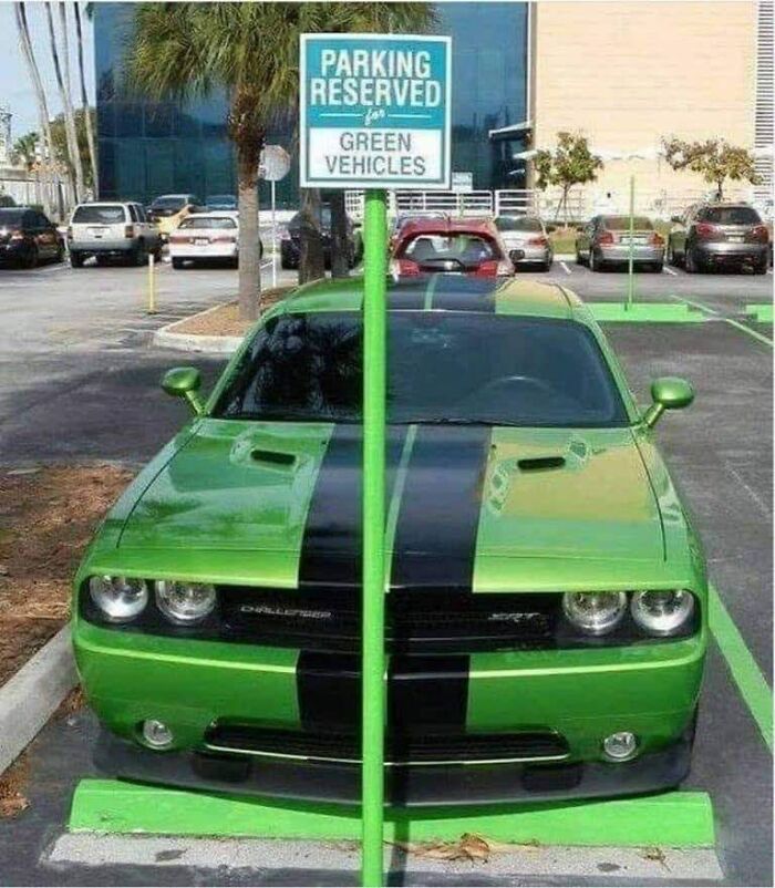 Green Dodge Challenger parked in a spot reserved for green vehicles, illustrating an example of bad drivers.