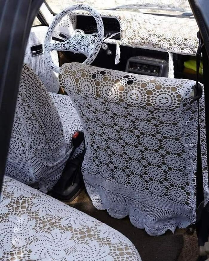 Car interior covered entirely in white lace covers, featured in a Facebook group about bad drivers.