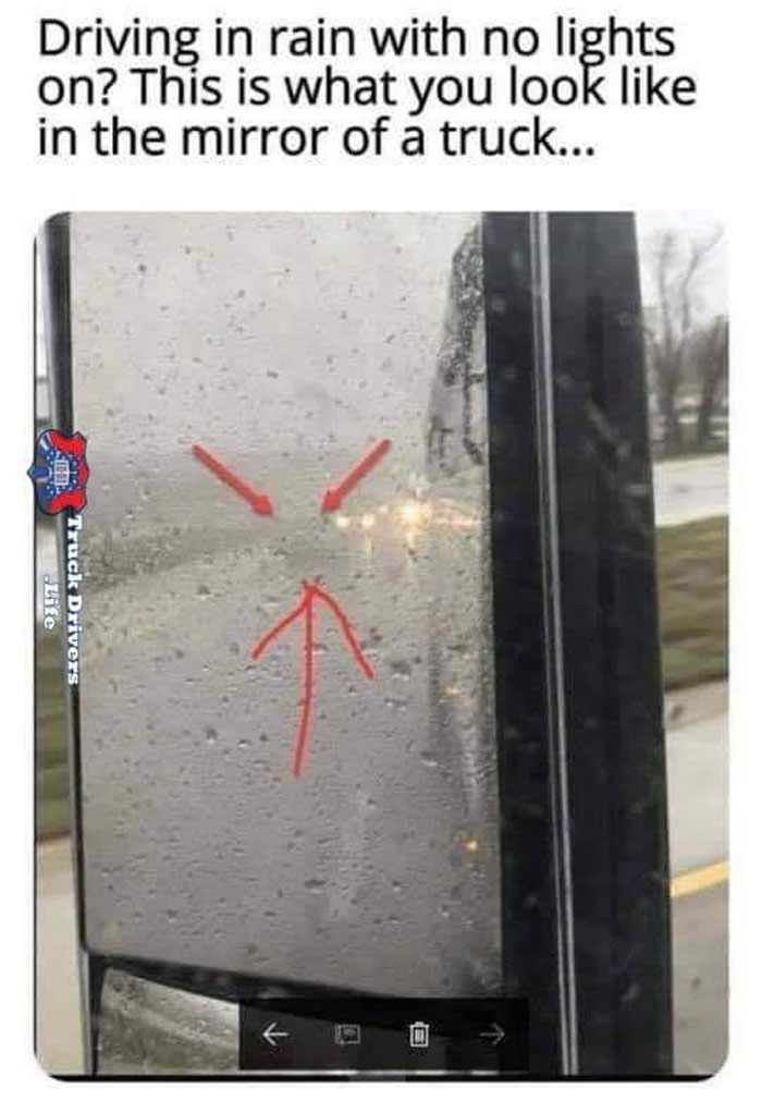 View of rainy truck mirror showing a car with no lights on, highlighting bad drivers documented in a Facebook group.