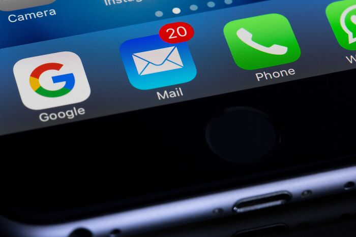 Close-up of a smartphone screen showing mail, phone, and app icons with notification badge highlighting past communication methods.