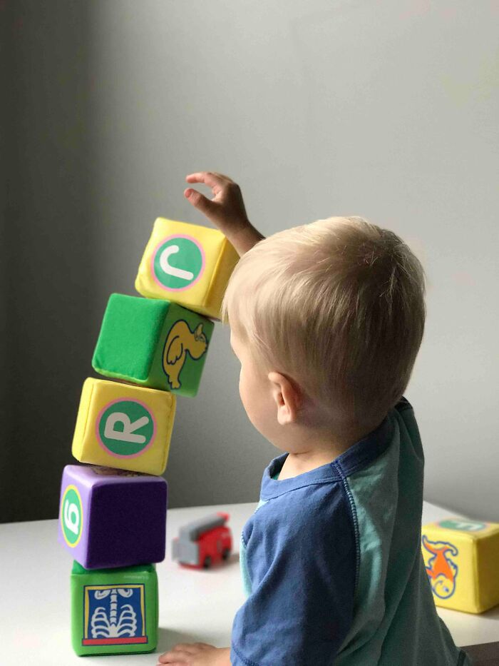 Toddler stacking colorful soft blocks, illustrating curiosity about what was actually better in the past.
