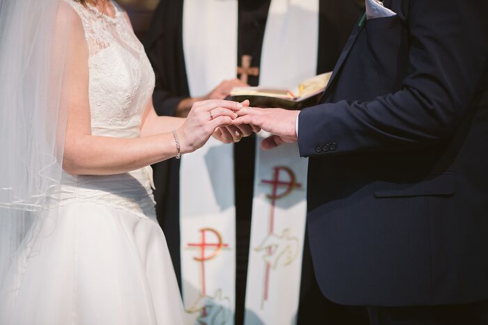 Bride and groom exchanging rings during a wedding ceremony, illustrating one of the weirdest wedding experiences shared by community.