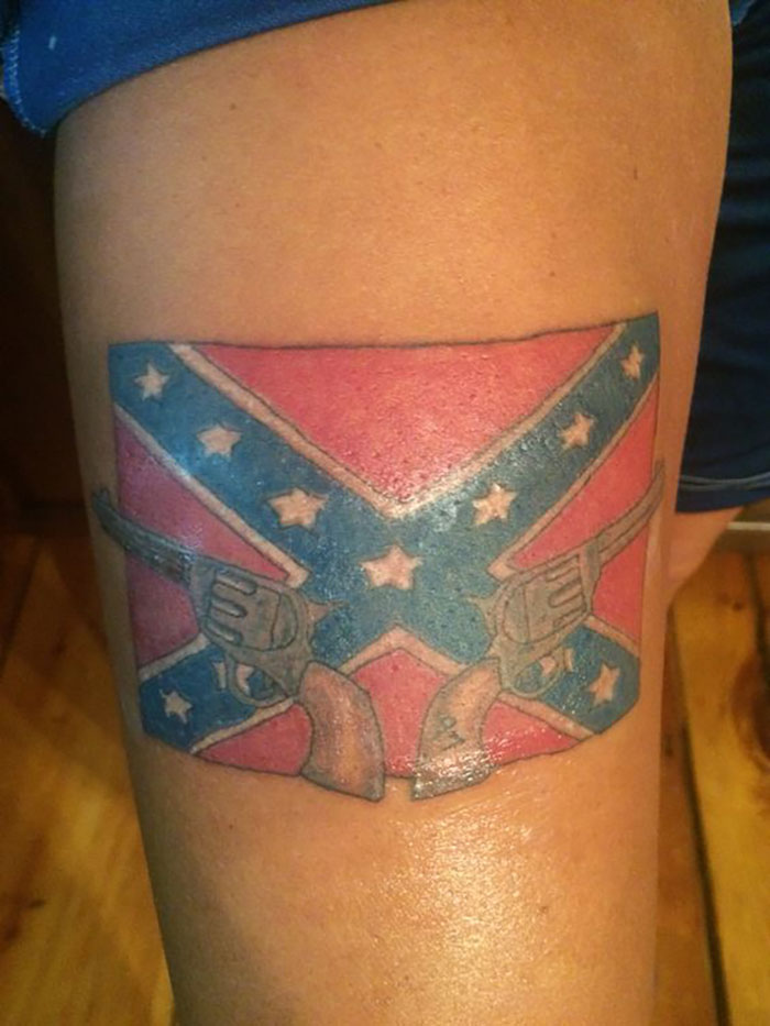 Confederate flag tattoo with revolvers on a person's thigh, highlighting potential red flags in tattoos.