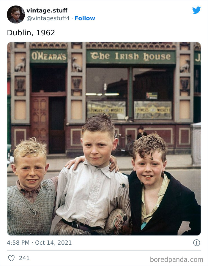 Three boys posing outside The Irish House pub in Dublin, 1962, in a colorized photo showcasing stunning historical moments.