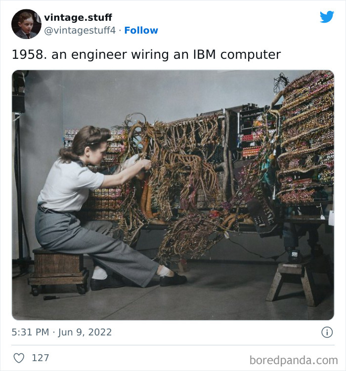 Engineer wiring an IBM computer in 1958 with complex cables and circuits in a historic colorized photo from the collection.