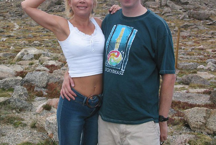 Couple posing outdoors on rocky terrain, illustrating communication issues guys should never say to their partners.