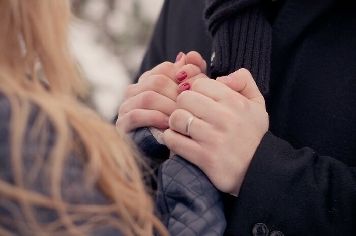 A couple holding hands closely, illustrating relationship and things guys should never say to their partners.